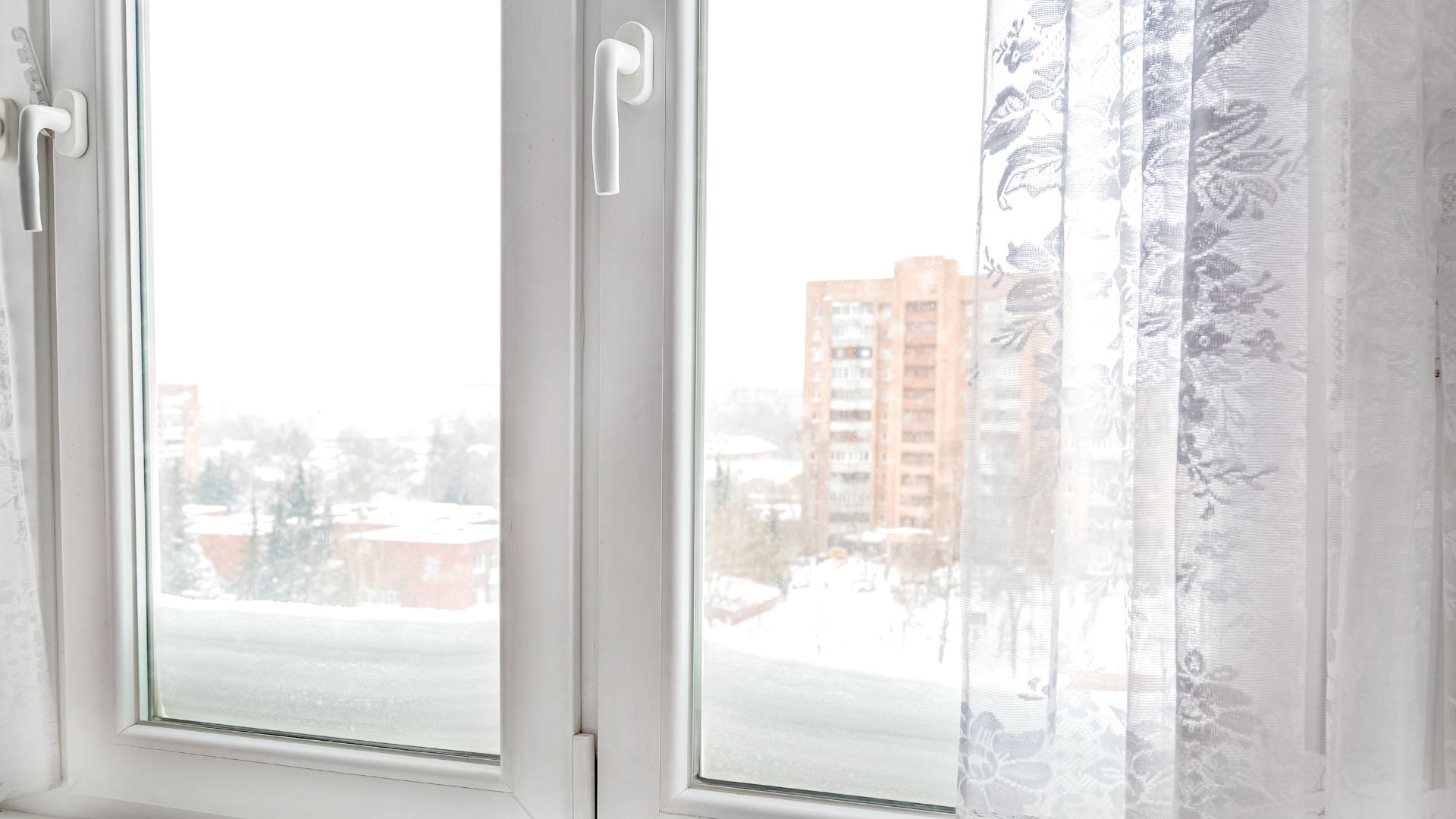 White-framed window with a snowy view outside.